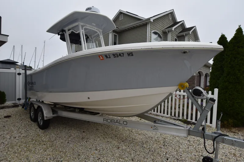 Slide: The Image of 2023 Robalo R230 Center Console boat on trailer, parked in residential area. - 8