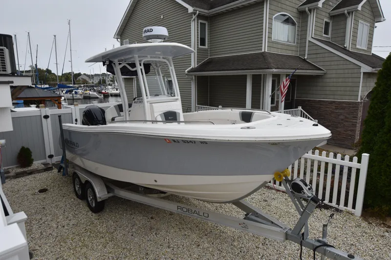 Slide: The Image of 2023 Robalo R230 Center Console boat on trailer in residential driveway. - 9