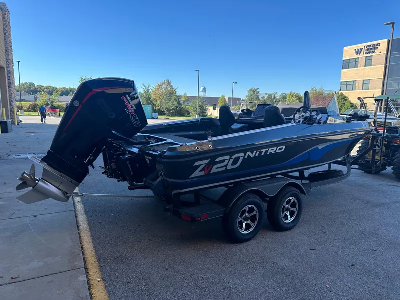 Slide: The Image of 2024 Nitro ZV20 boat with outboard motor on a trailer, parked outdoors. - 2