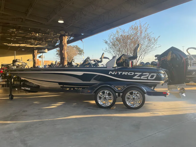 Slide: The Image of 2023 Nitro Z20 boat with sleek design and dual-axle trailer in outdoor setting. - 0