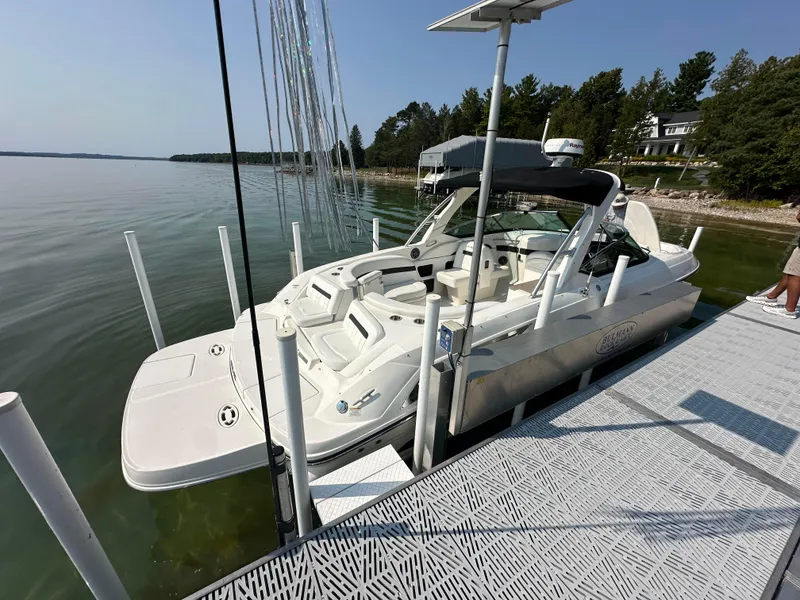 Slide: The Image of 2015 Sea Ray 300 SLX boat docked on a serene lake with lush greenery. - 1