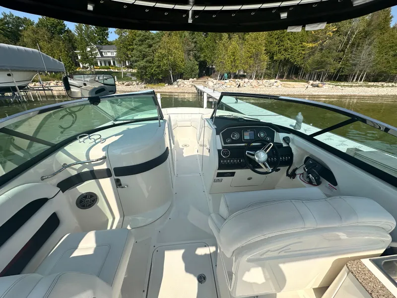 Slide: The Image of 2015 Sea Ray 300 SLX boat interior with white seating and control panel. - 14