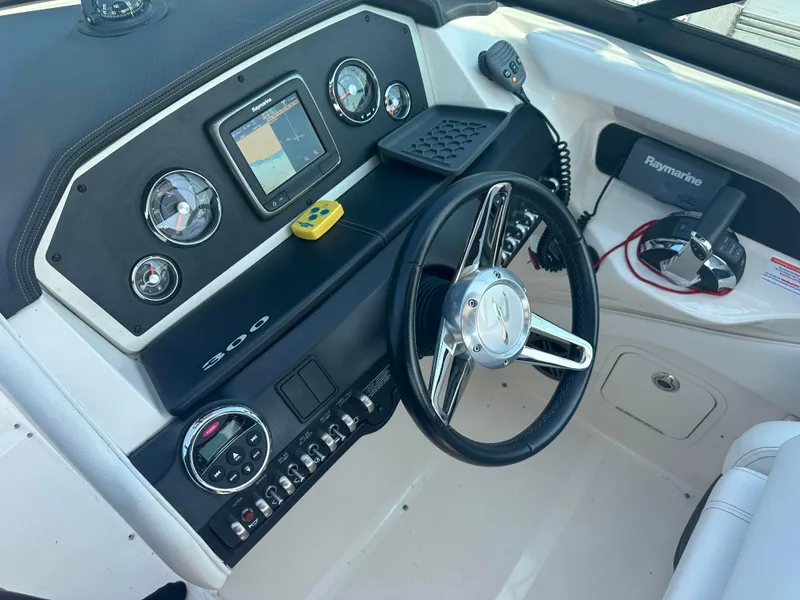 Slide: The Image of 2015 Sea Ray 300 SLX boat dashboard with steering wheel and navigation controls. - 16