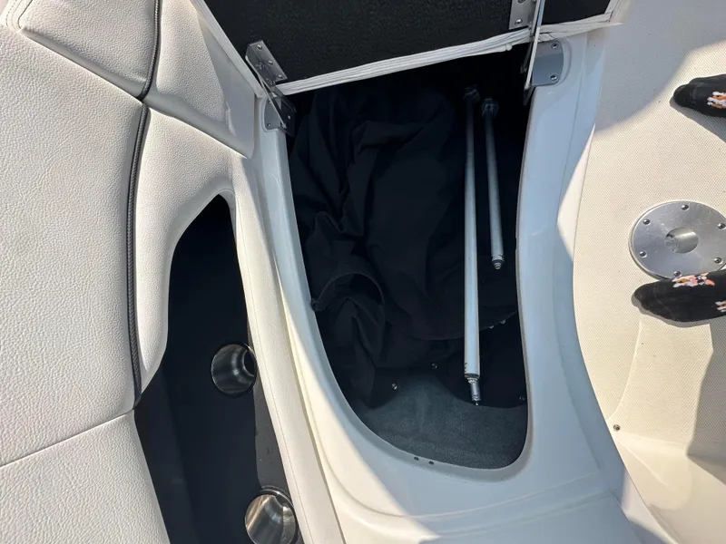 Slide: The Image of Open storage compartment on 2015 Sea Ray 300 SLX boat with accessories inside. - 25