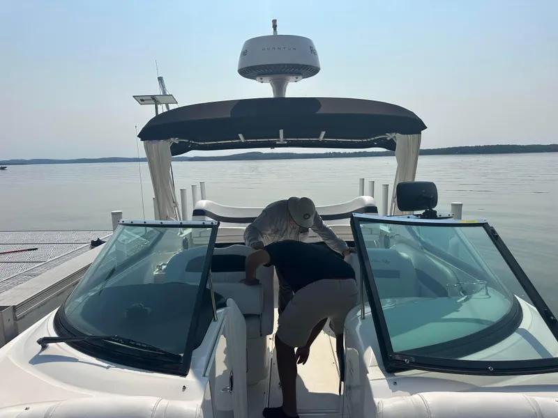Slide: The Image of 2015 Sea Ray 300 SLX boat docked on a calm lake with two people onboard. - 6