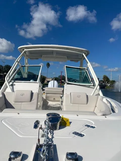 Slide: The Image of 2025 Sailfish 245 DC boat with open deck, clear sky, and waterfront view. - 1