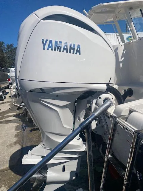 Slide: The Image of 2025 Sailfish 245 DC with Yamaha outboard motor in marina setting. - 11