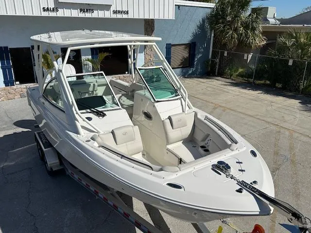 Slide: The Image of 2025 Sailfish 245 DC boat on trailer, parked outside a service center. - 13