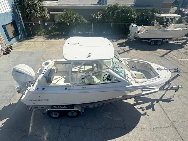 Slide: The Image of 2025 Sailfish 245 DC boat on trailer, parked outdoors, viewed from above. - 17