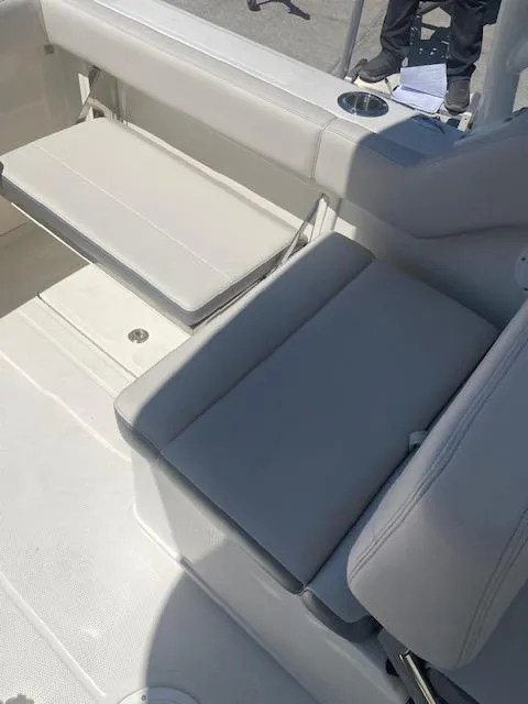 Slide: The Image of 2025 Sailfish 245 DC boat interior with gray seating and cup holder. - 4