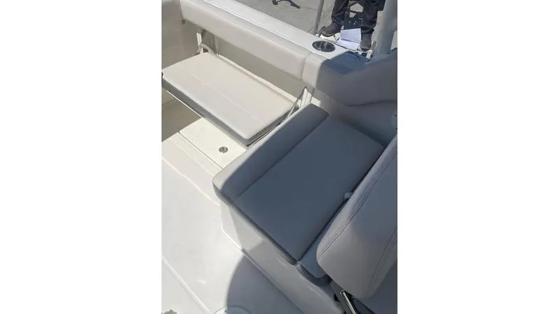 Slide: The Image of 2025 Sailfish 245 DC boat interior with cushioned seating and cup holder. - 5