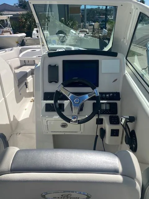 Slide: The Image of 2025 Sailfish 245 DC boat cockpit with modern steering and controls. - 7