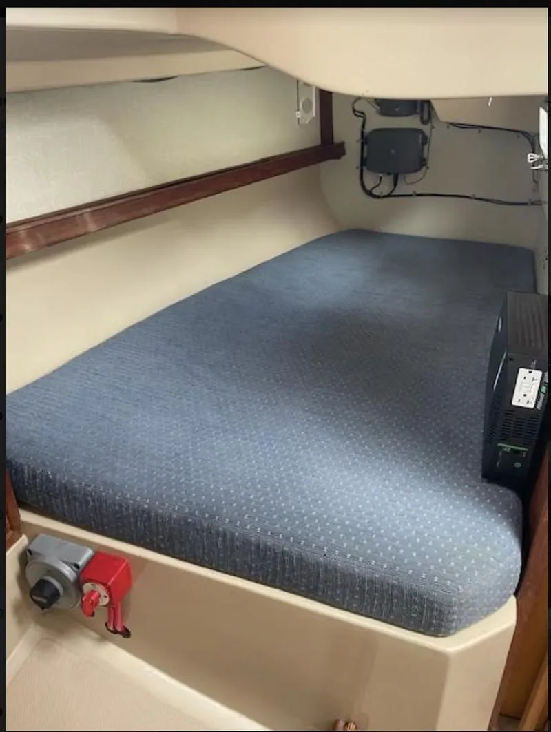 Slide: The Image of 1987 Island Packet 31 interior cabin with blue mattress and wooden trim. - 11