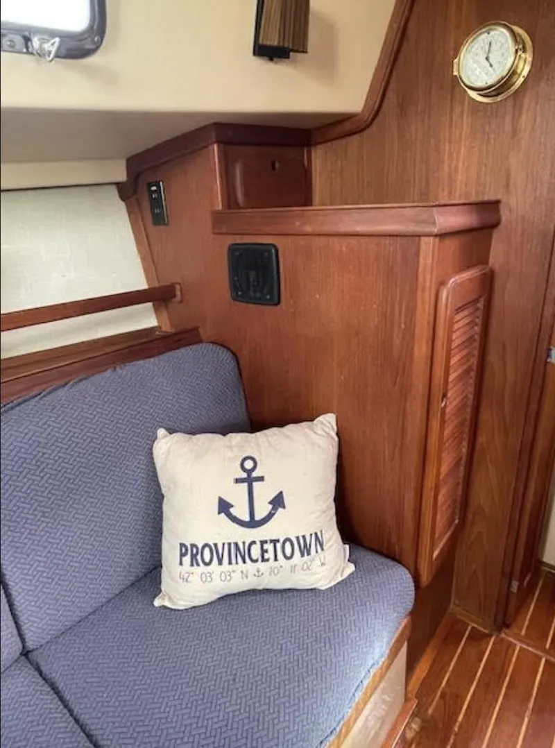 Slide: The Image of Interior of 1987 Island Packet 31 sailboat with nautical-themed cushion and wooden paneling. - 13
