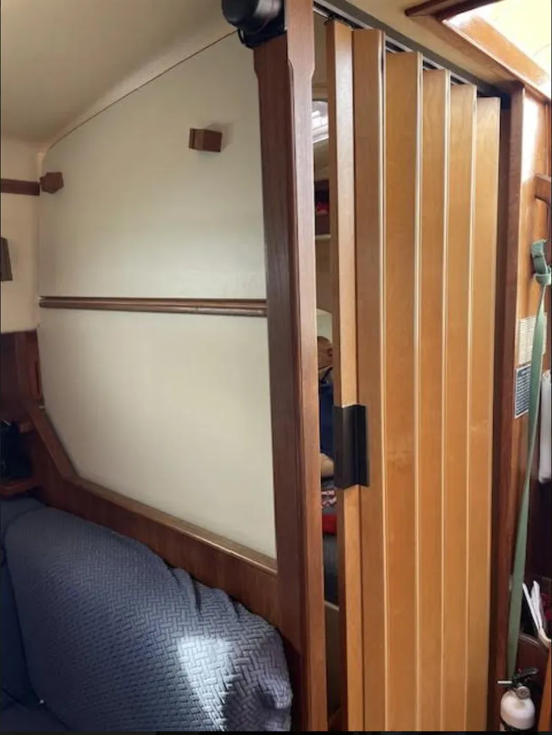 Slide: The Image of 1987 Island Packet 31 interior with wooden sliding door and cozy seating area. - 14