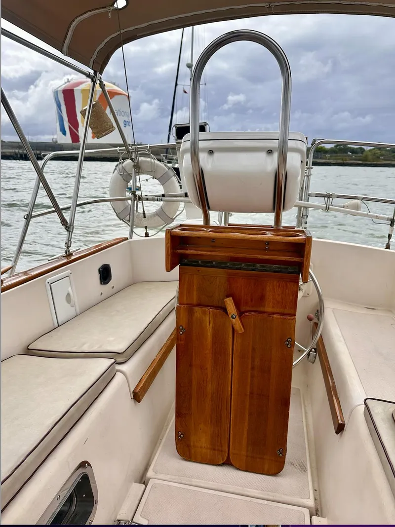 Slide: The Image of 1987 Island Packet 31 sailboat cockpit with wooden helm and seating. - 3