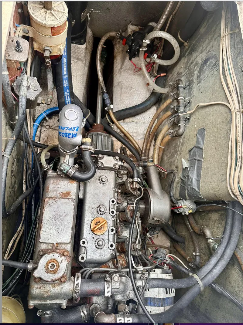 Slide: The Image of Engine compartment of a 1987 Island Packet 31 sailboat, showing mechanical components and wiring. - 4