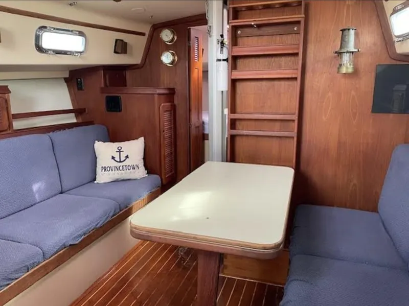 Slide: The Image of Interior of 1987 Island Packet 31 sailboat with cozy seating and wooden finishes. - 8