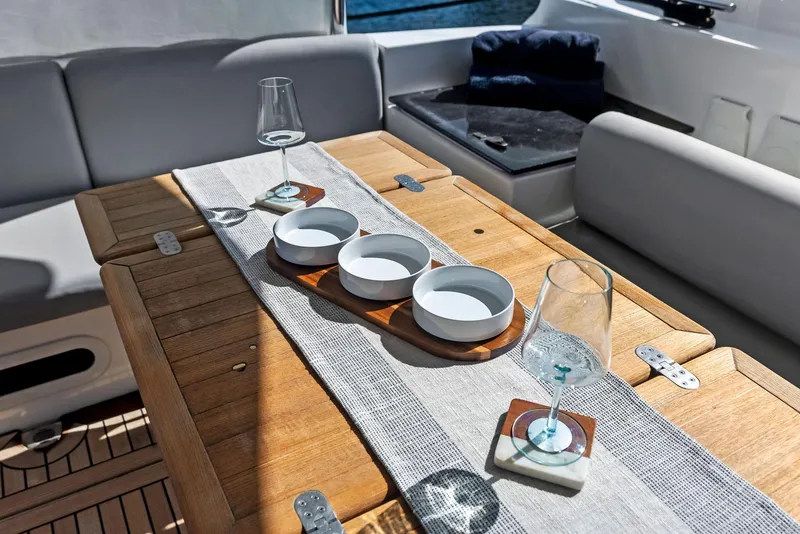 Slide: The Image of Luxury yacht dining area with wooden table, glassware, and bowls on Absolute 55 FLY, 2013 model. - 19