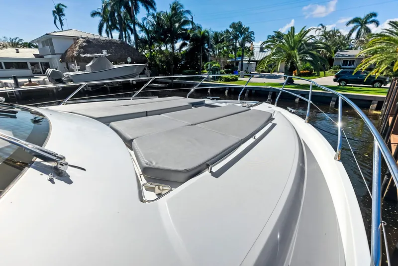 Slide: The Image of Luxury Absolute 55 FLY yacht deck with sun loungers, 2013 model, docked near palm trees. - 23