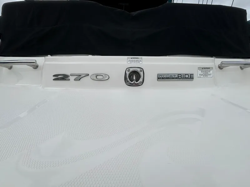 Slide: The Image of 2013 Sea Ray 270 SLX boat rear view with logos and black cover. - 10