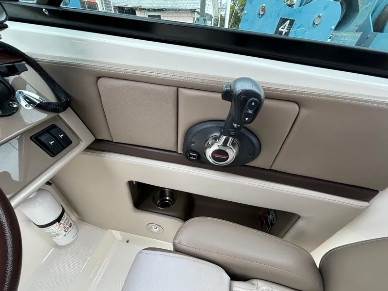Slide: The Image of Interior view of 2013 Sea Ray 270 SLX boat, featuring control panel and throttle lever. - 15