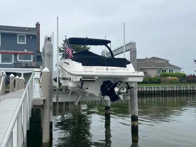 Slide: The Image of 2013 Sea Ray 270 SLX boat docked on a lift by waterfront homes. - 2