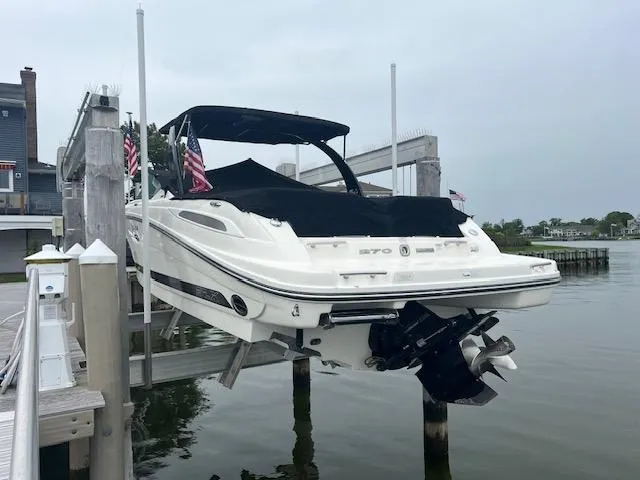 Slide: The Image of 2013 Sea Ray 270 SLX boat docked on a lift by the water. - 3