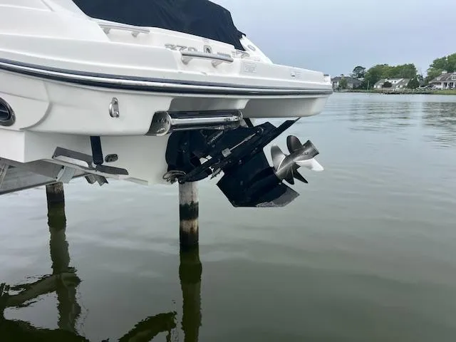 Slide: The Image of 2013 Sea Ray 270 SLX boat with dual propellers, docked on calm water. - 5