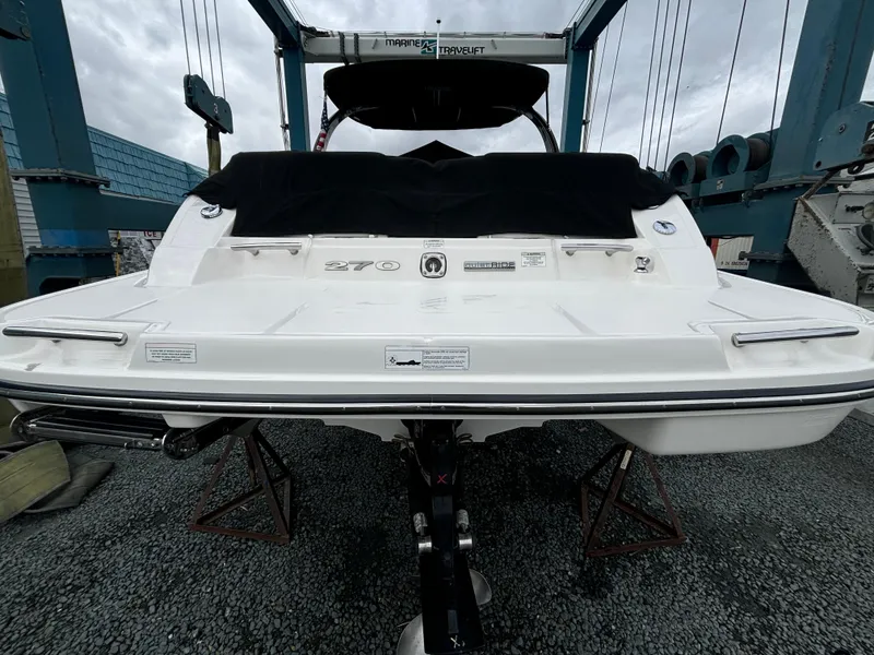 Slide: The Image of 2013 Sea Ray 270 SLX boat on stands, rear view, in a marina setting. - 8