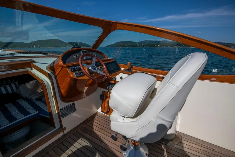 Slide: The Image of 2004 Hinckley Talaria 29 Runabout interior with wooden dashboard and white captain's chair. - 16