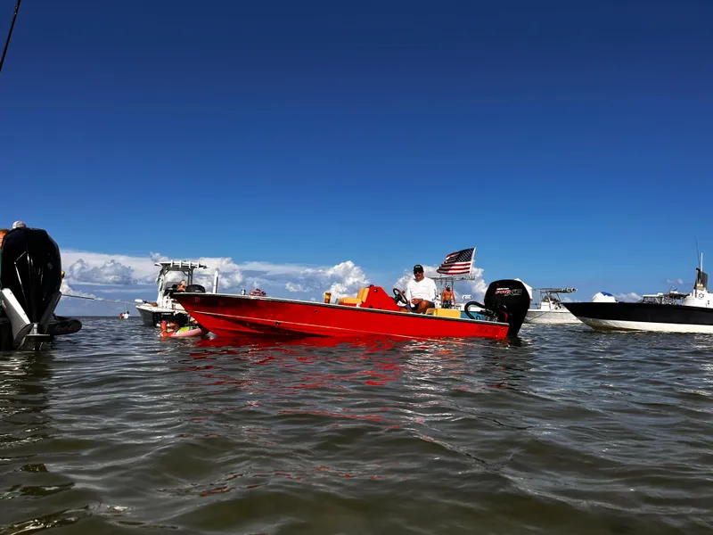 Slide: The Image of Red ZCB Curlew 18 boat on water, 2023 model, with clear blue sky background. - 10
