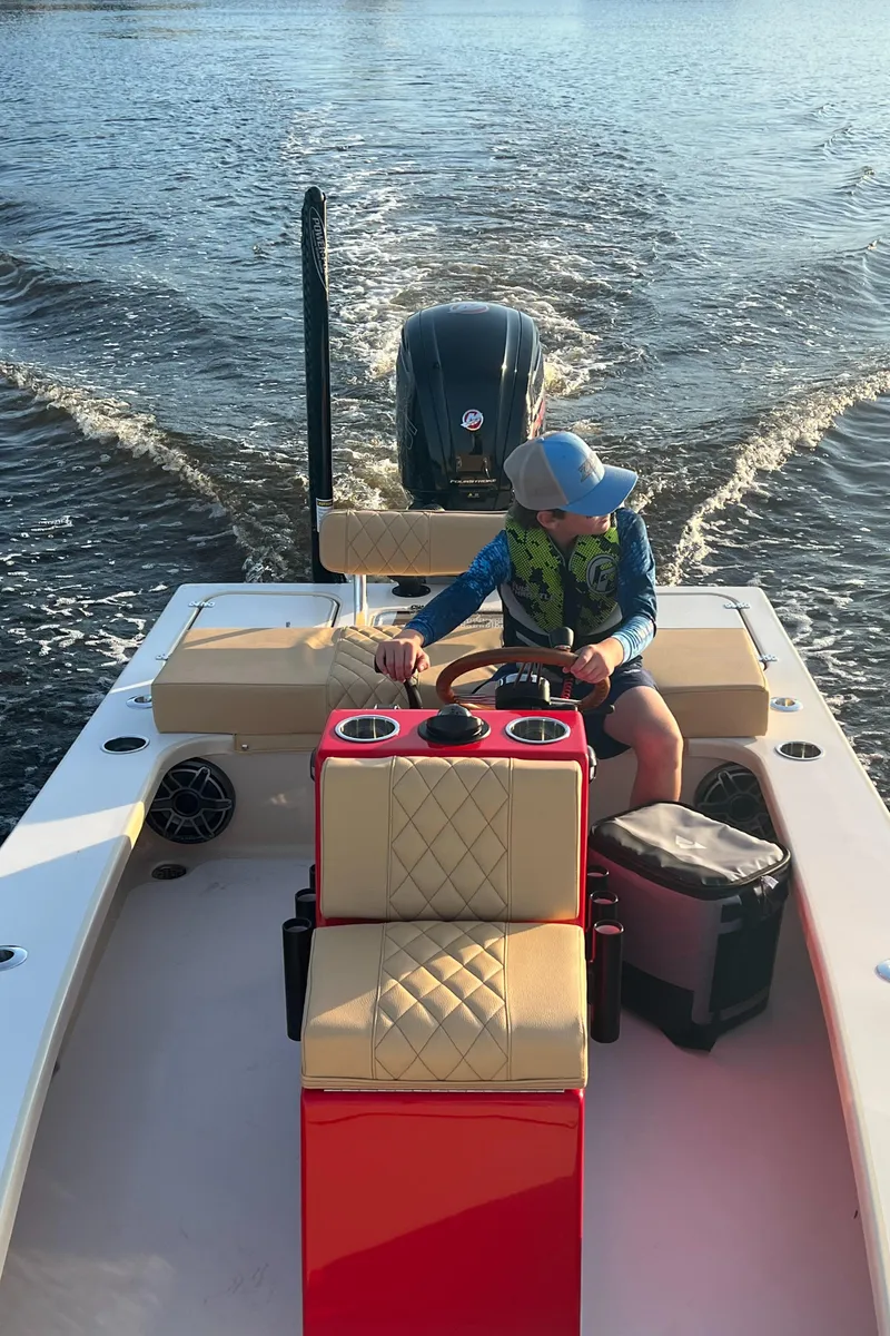 Slide: The Image of 2023 ZCB Curlew 18 boat on water, person steering, sunny day. - 12