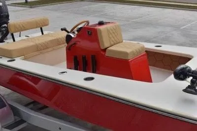 Slide: The Image of 2023 ZCB Curlew 18 boat with red console and beige seating on a trailer. - 5