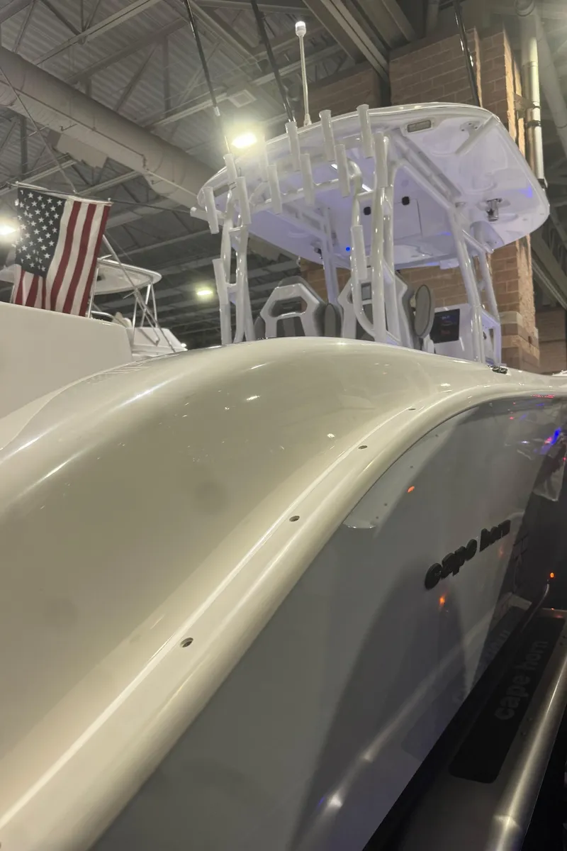 Slide: The Image of 2023 Cape Horn 34 XS boat displayed indoors with American flag. - 6