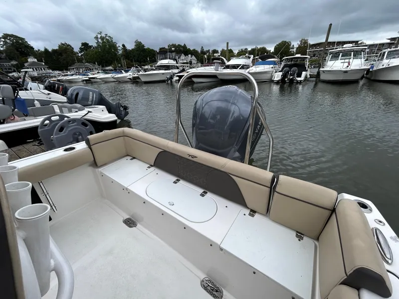 Slide: The Image of 2021 Tidewater 232 LXF boat docked in a marina, surrounded by other boats. - 10