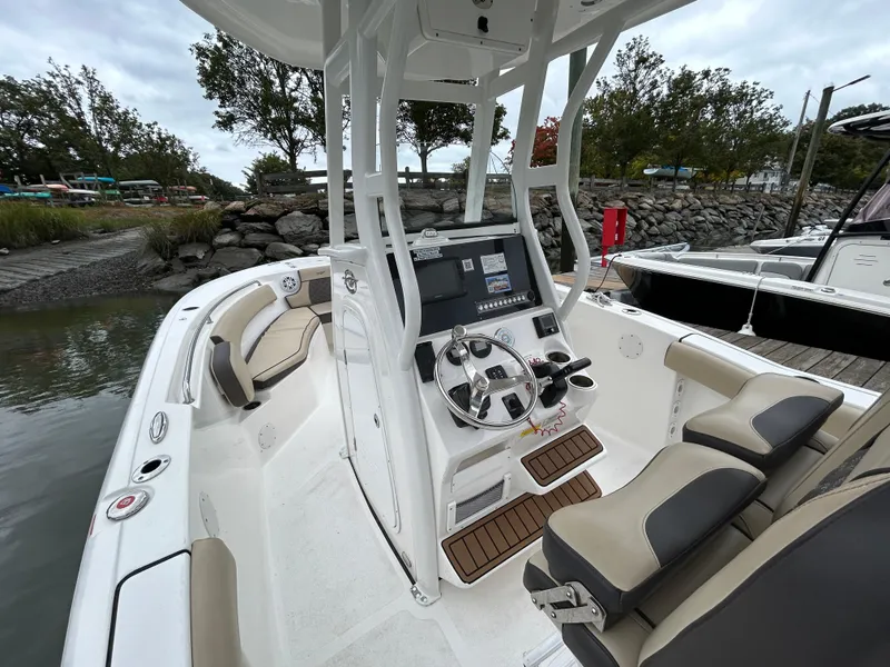 Slide: The Image of 2021 Tidewater 232 LXF boat interior with helm, seating, and console at dock. - 14
