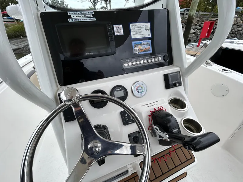 Slide: The Image of 2021 Tidewater 232 LXF boat dashboard with steering wheel and control panel. - 8