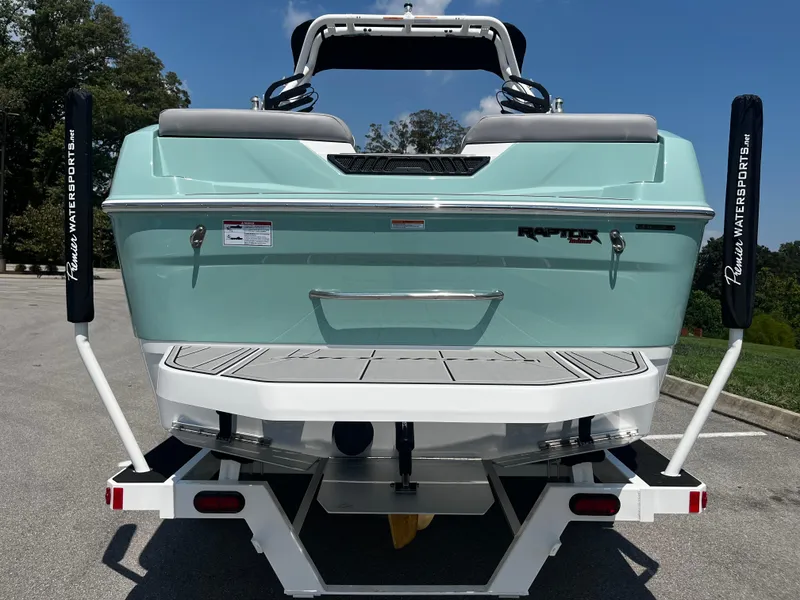 Slide: The Image of 2025 Moomba Max boat on trailer, rear view, mint green color, parked outdoors. - 3
