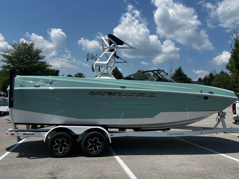 Slide: The Image of 2025 Moomba Max boat on trailer, parked outdoors under a blue sky. - 5