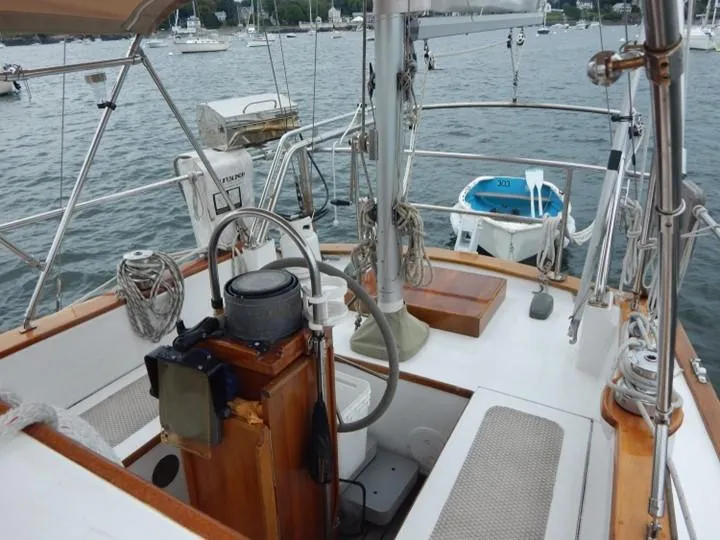 Slide: The Image of 1986 Covey Island 38 sailboat cockpit with steering wheel, ropes, and seating, docked in a marina. - 10