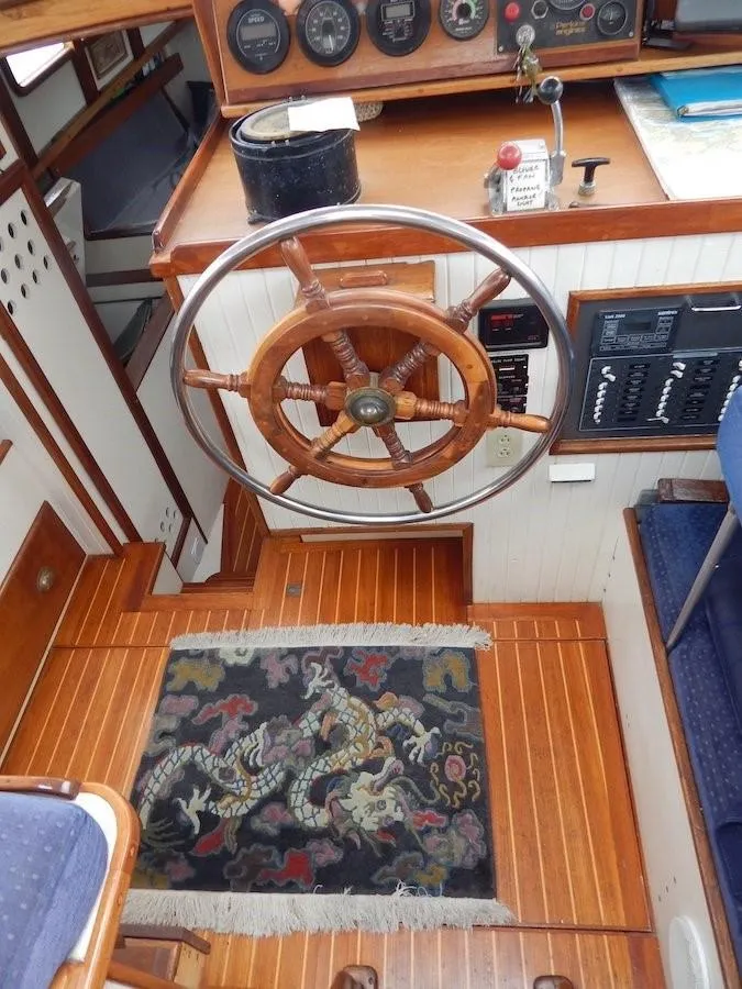 Slide: The Image of 1986 Covey Island 38 boat interior with wooden steering wheel and nautical instruments. - 13