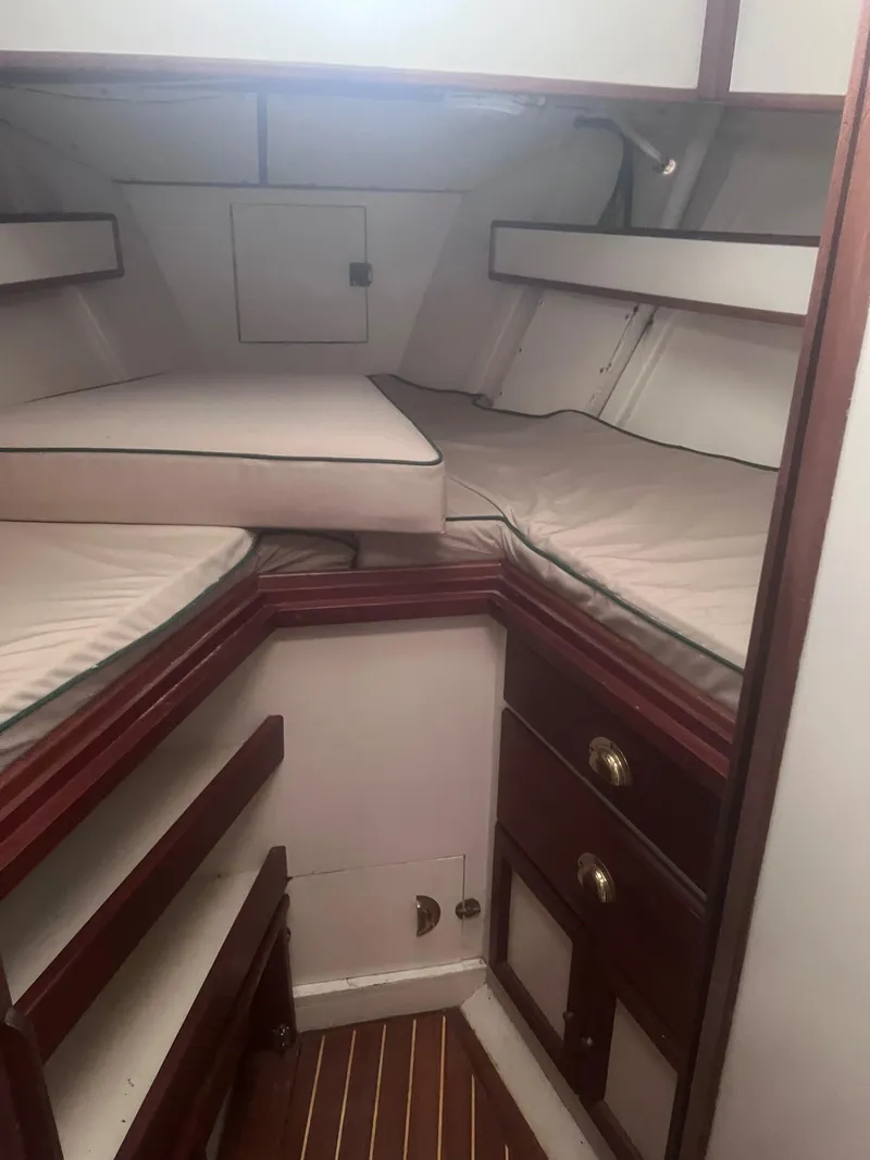Slide: The Image of 1986 Covey Island 38 interior cabin with wooden trim and cushioned berths. - 18