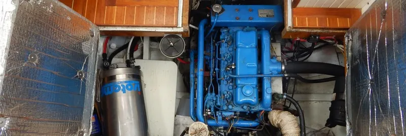 Slide: The Image of Engine compartment of a 1986 Covey Island 38 boat with blue engine and insulation. - 23