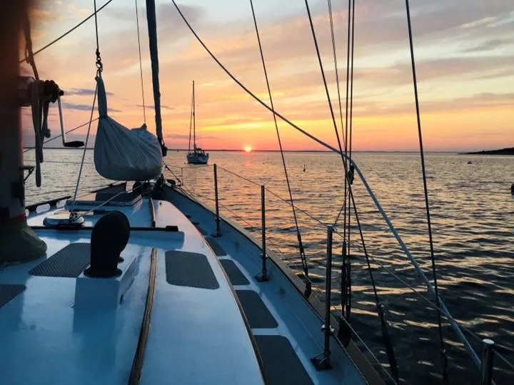 Slide: The Image of Sailboat Covey Island 38, 1986 model, at sunset on calm waters. - 4