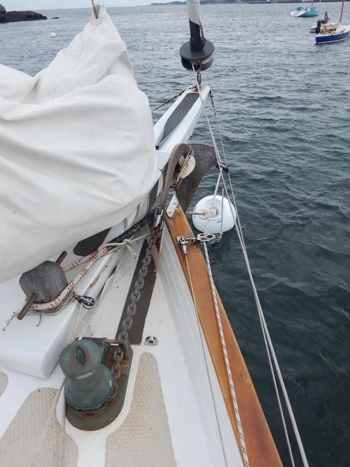 Slide: The Image of Covey Island 38 sailboat deck, 1986 model, with anchor and ropes on calm water. - 5