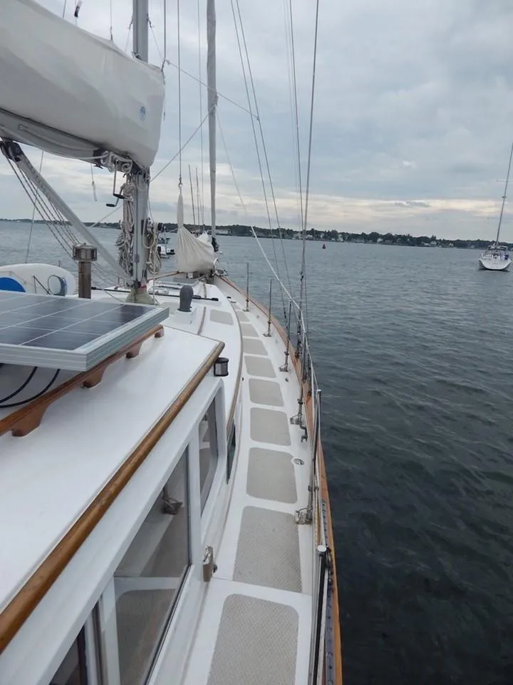 Slide: The Image of 1986 Covey Island 38 sailboat on calm waters, featuring a spacious deck and solar panel. - 8