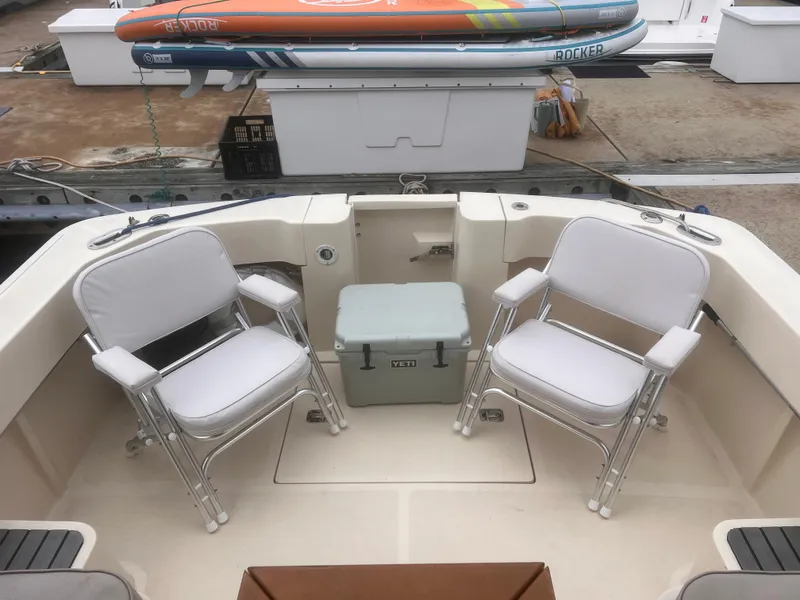 Slide: The Image of 2004 Mainship 30 Pilot II Express Cruiser deck with chairs and cooler. - 10