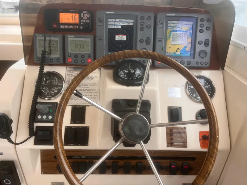 Slide: The Image of 2004 Mainship 30 Pilot II Express Cruiser dashboard with navigation instruments and steering wheel. - 15