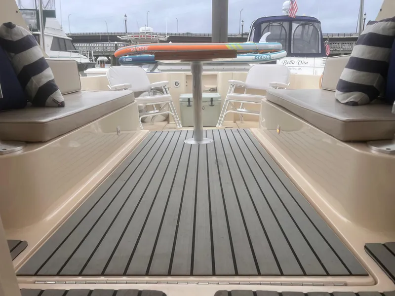 Slide: The Image of 2004 Mainship 30 Pilot II Express Cruiser interior with cushioned seating and striped pillows. - 17